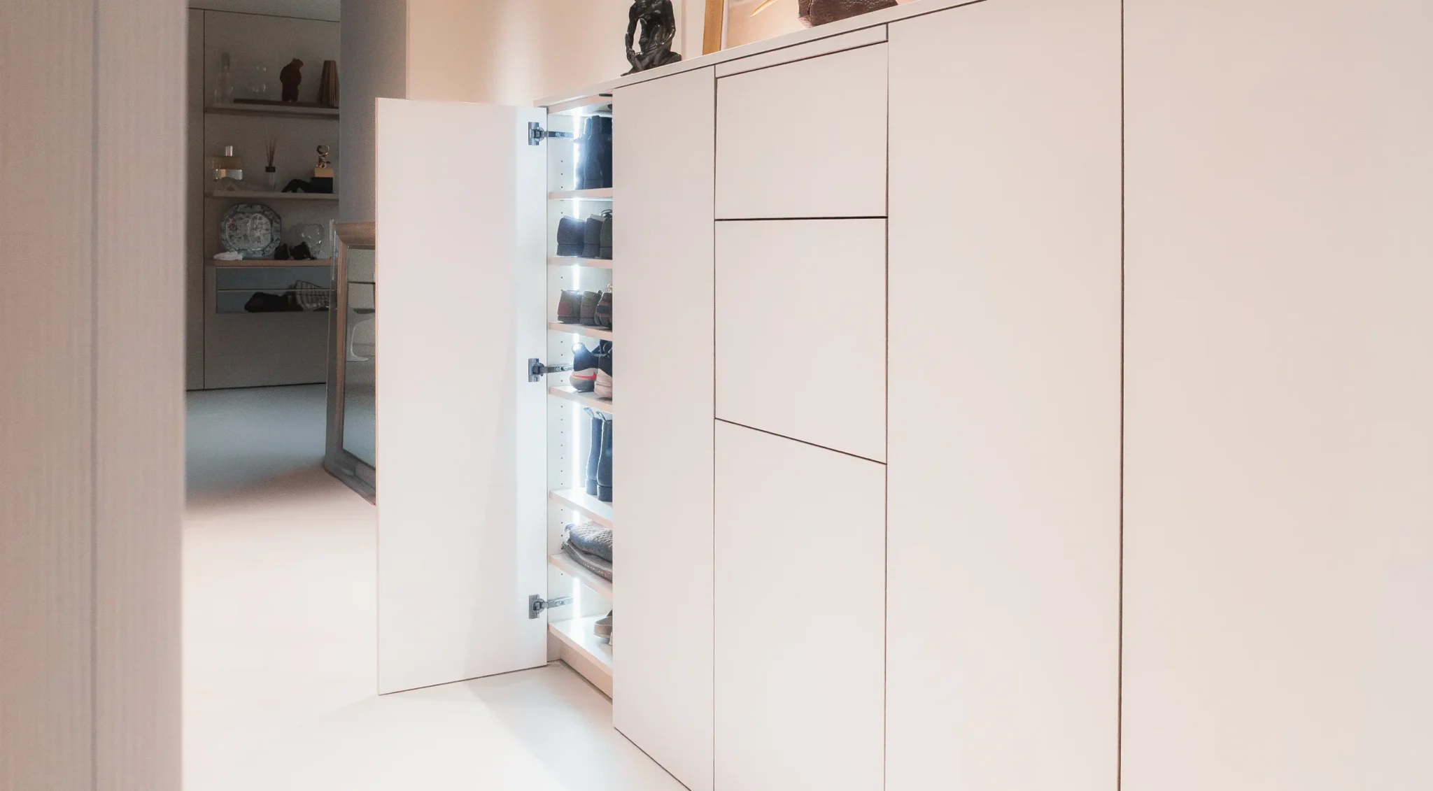 Entrée optimisée avec meuble discret et tablette pour l’entretien chaussures.